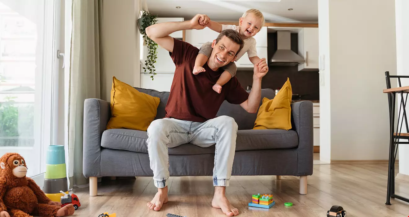 Pappa med litet barn på axlarna 