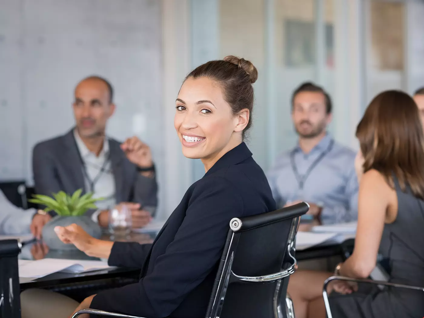 En grupp kollegor runt ett konferensbord, de ser glada ut och verkar ha roligt på jobbet. En kvinna ser ut att vara chef.